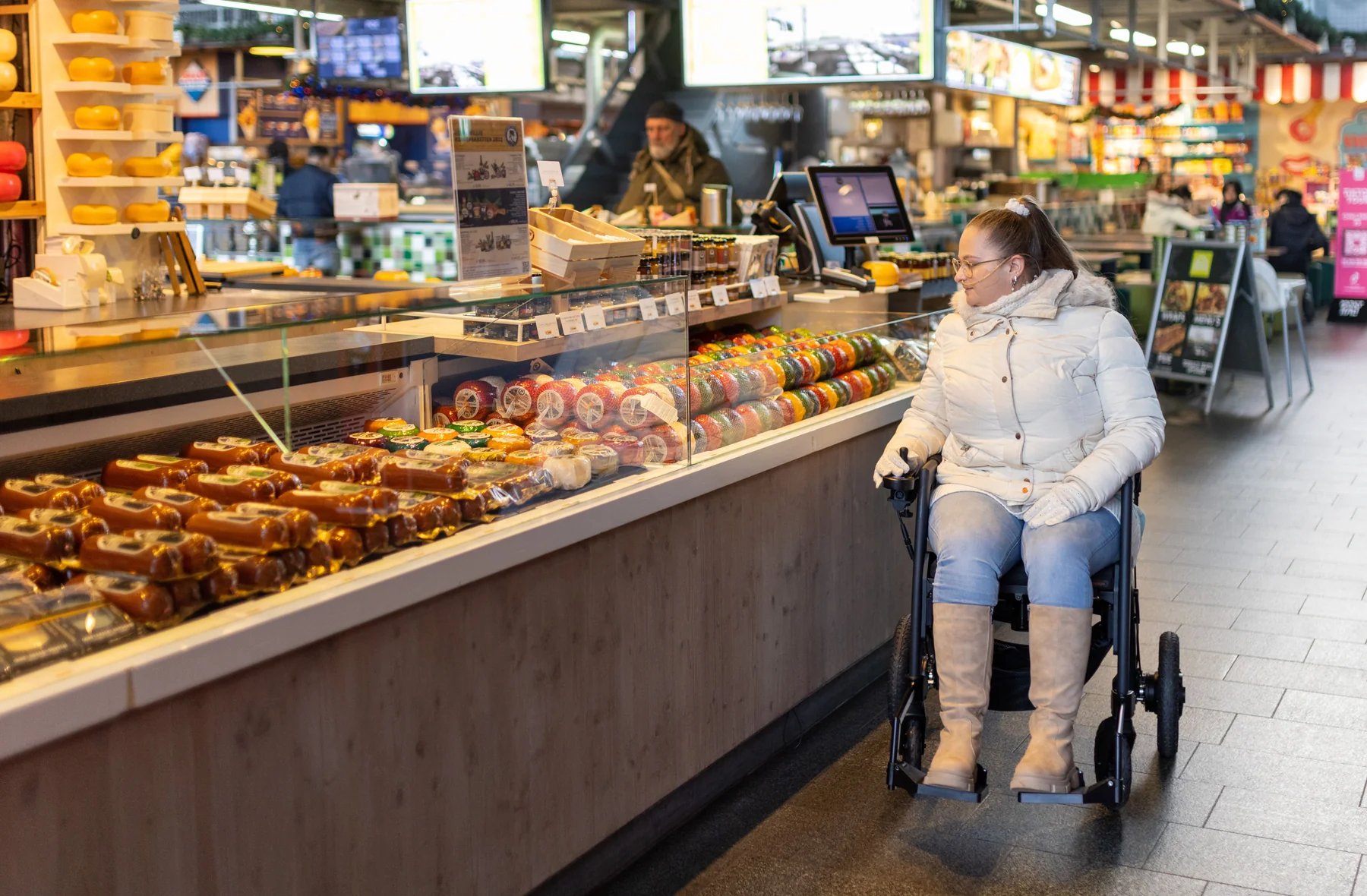 A wheelchair user browsing a food stall at a market